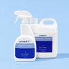 Two white bottles of protectME Premium Fabric Protector, one 750ml spray bottle in the foreground and one larger 20L jug in the background, both with blue labels, set against a solid light blue background.