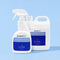 Two white bottles of protectME Premium Fabric Protector, one 750ml spray bottle in the foreground and one larger 20L jug in the background, both with blue labels, set against a solid light blue background.