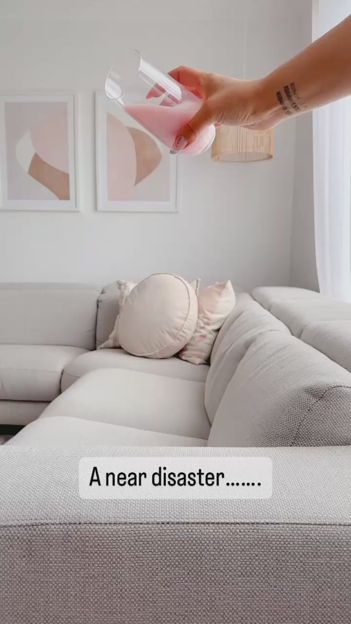 influencer applying protectME non-toxic fabric protector to their couch and spilling milk on it to show how the liquid beads off