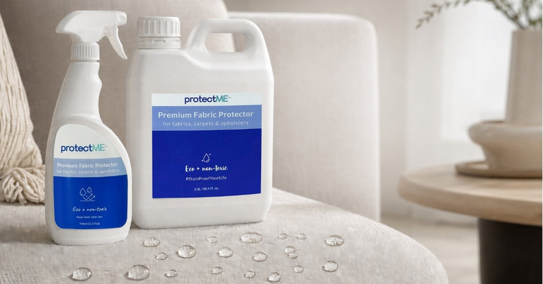 Two bottles of protectME non-toxic fabric protection products on a textured surface with a neutral background. There is also water droplets beading on the fabric instead of soaking in.