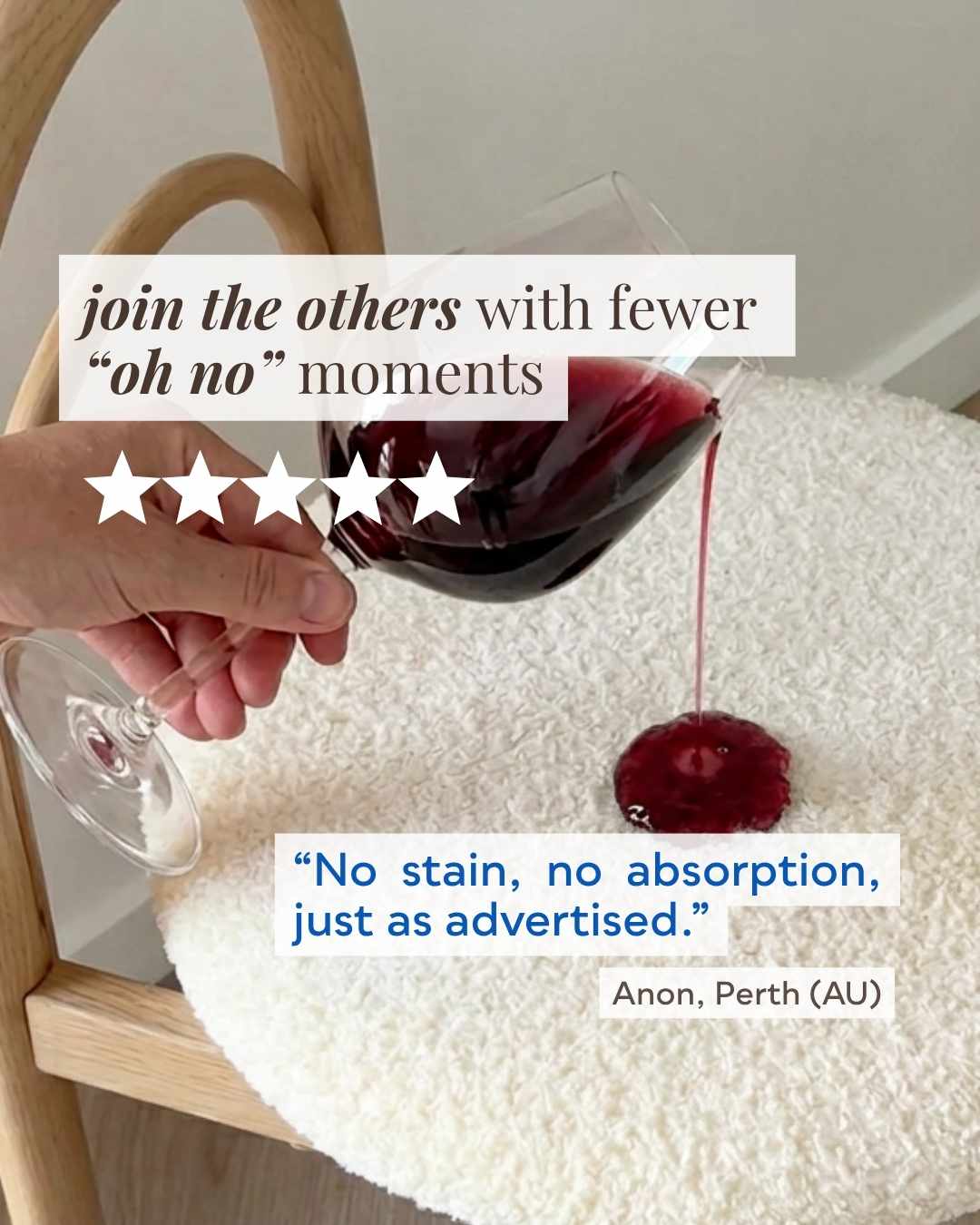 A hand holds a wine glass containing deep red wine above a white textured rug, with a small pool of red liquid on the rug. Text overlays claim stain-free absorption, and the photo includes a chair and a quote attribution.