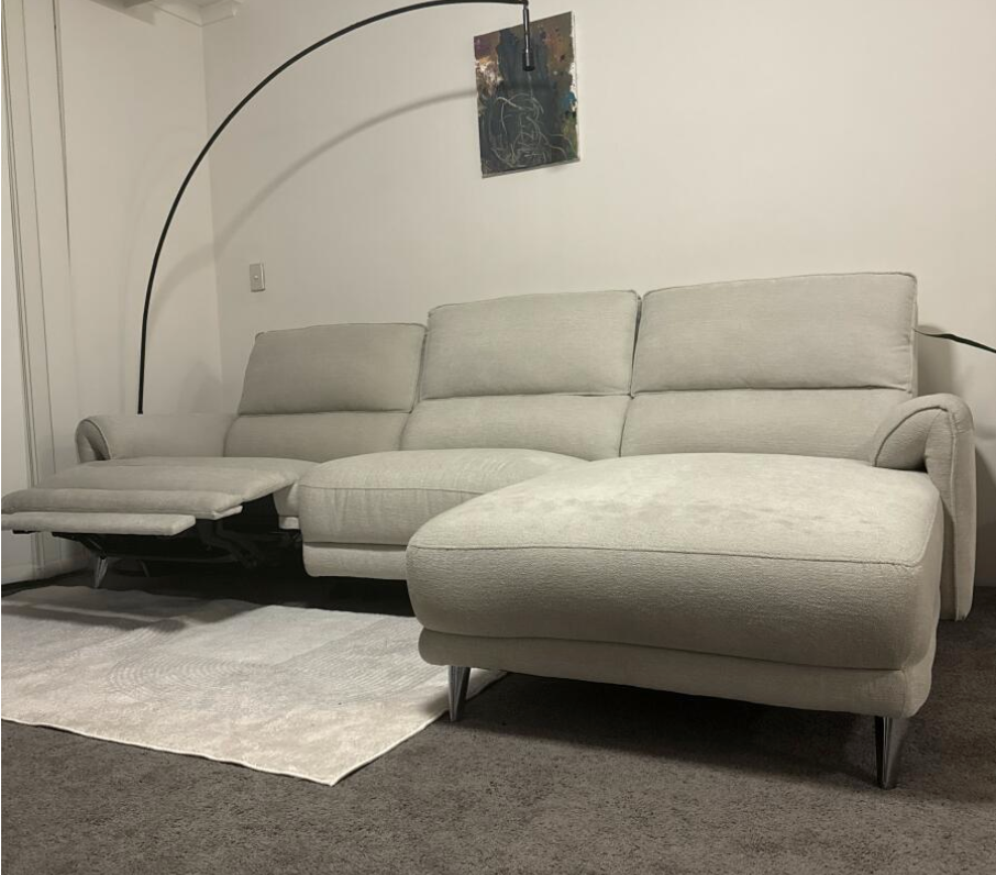 Gray sectional sofa in a room with a rug and wall art for protectME's customer testimonial photo
