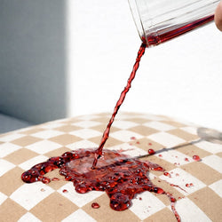 Red liquid being poured onto a checkered cushion